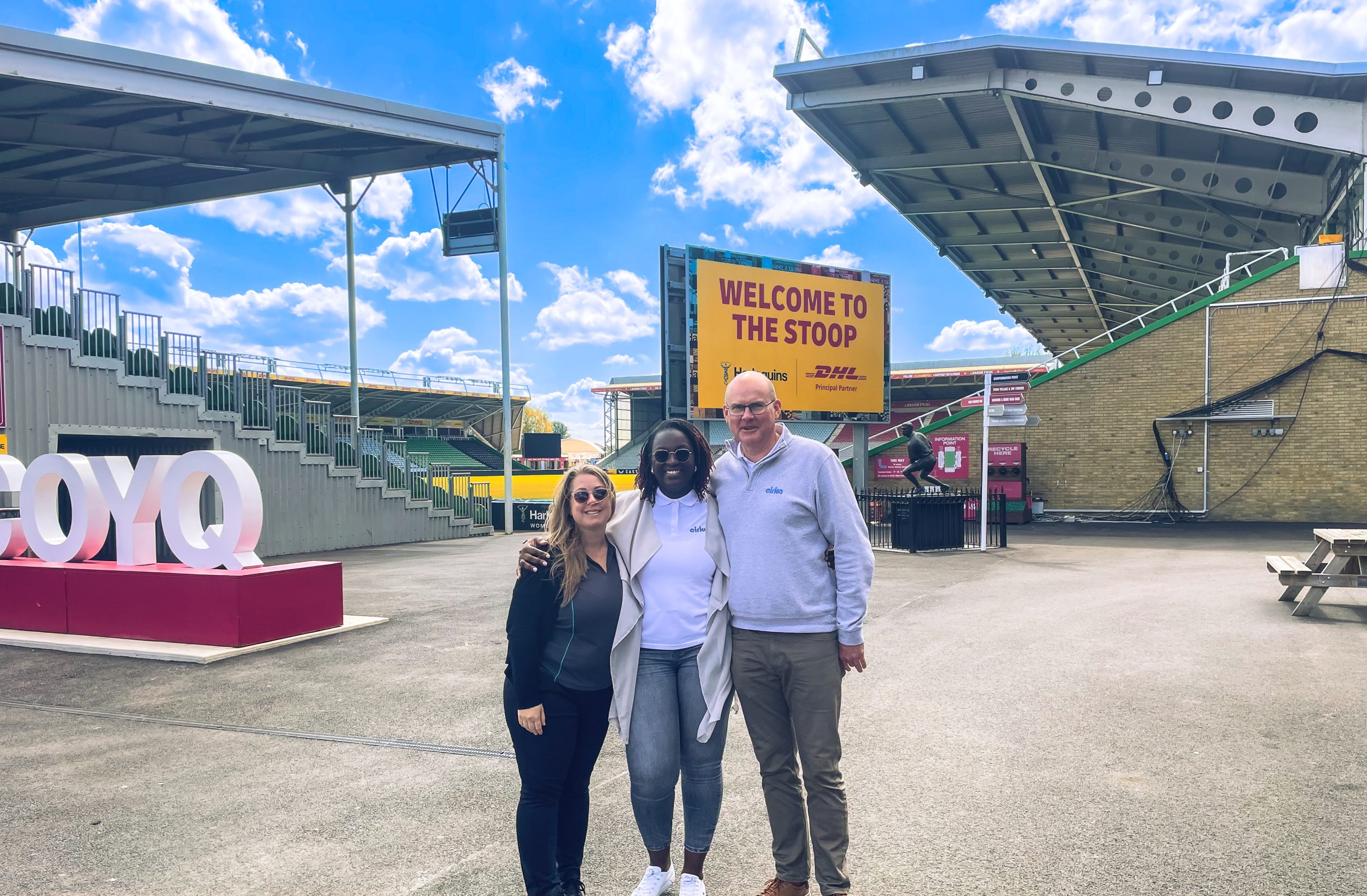 Three people in front of the stadium